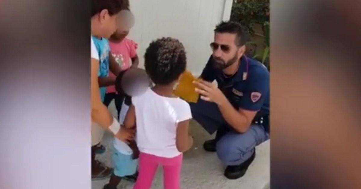 Poliziotto fa un trucco di magia per i piccoli migranti
