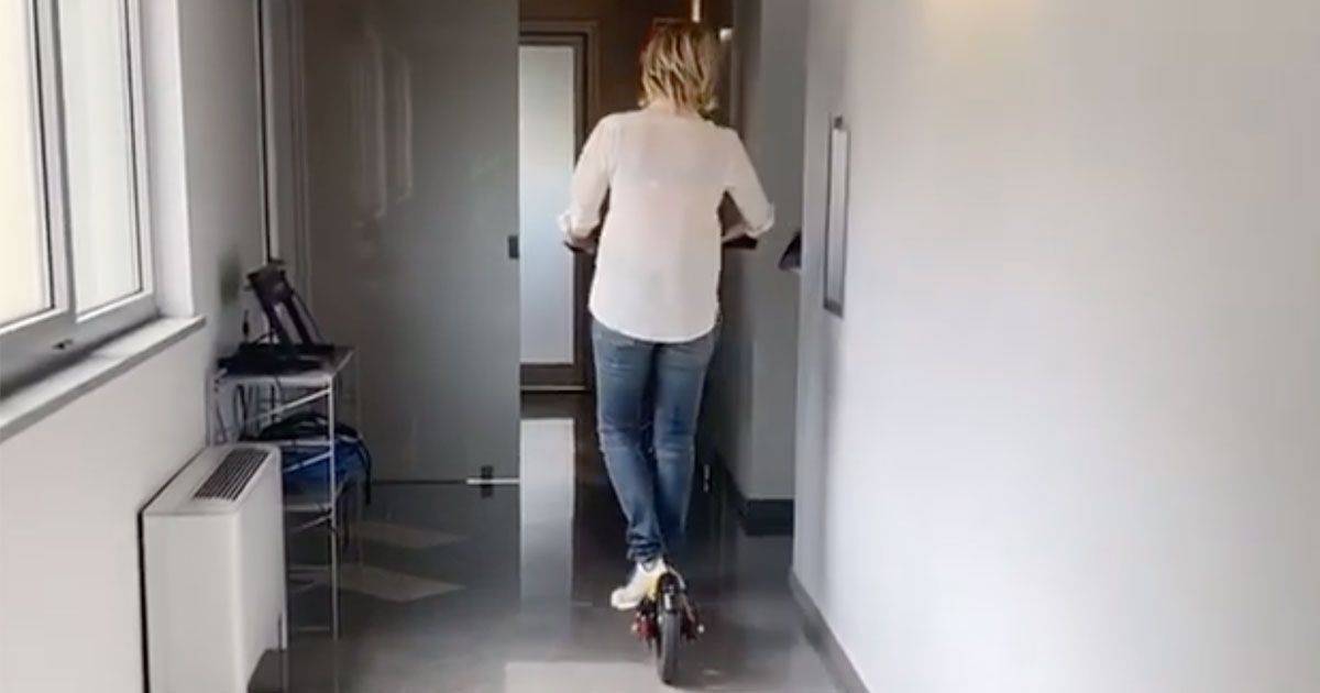 Maria De Filippi a bordo di un monopattino nei corridoi di Mediaset